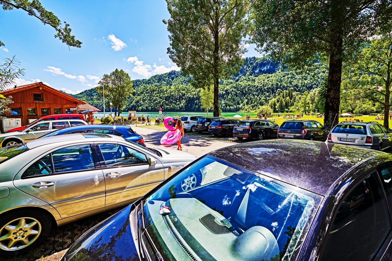 Blick auf einen vollen Parkplatz am See an einem Sommertag