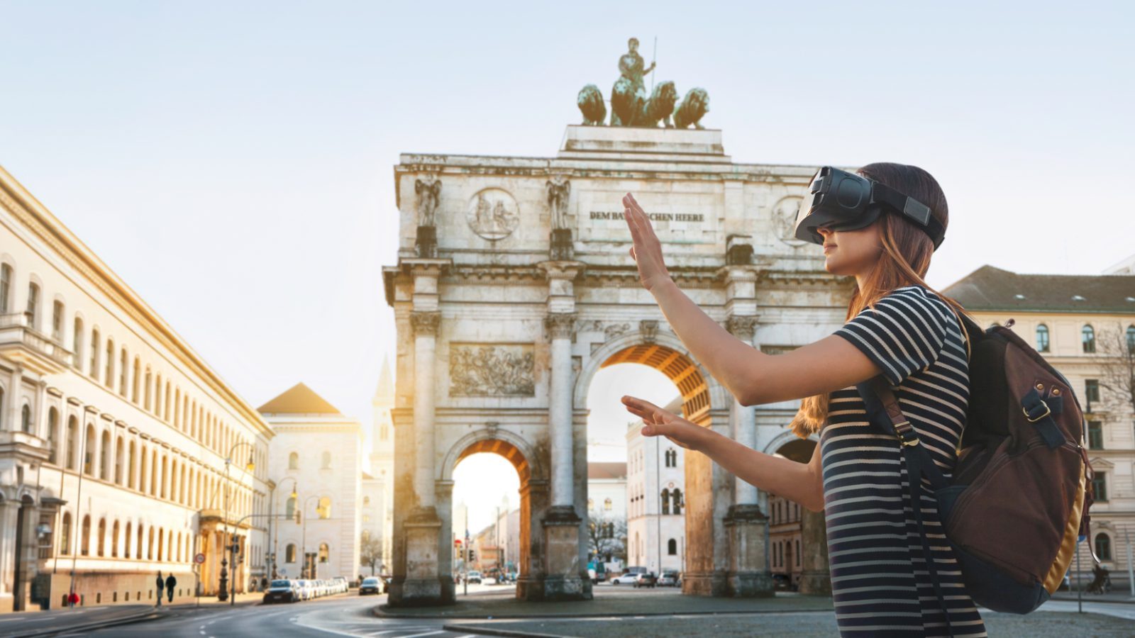 Frau mit VR-Brille interagiert vor einem historischen Tor in einer urbanen Umgebung.