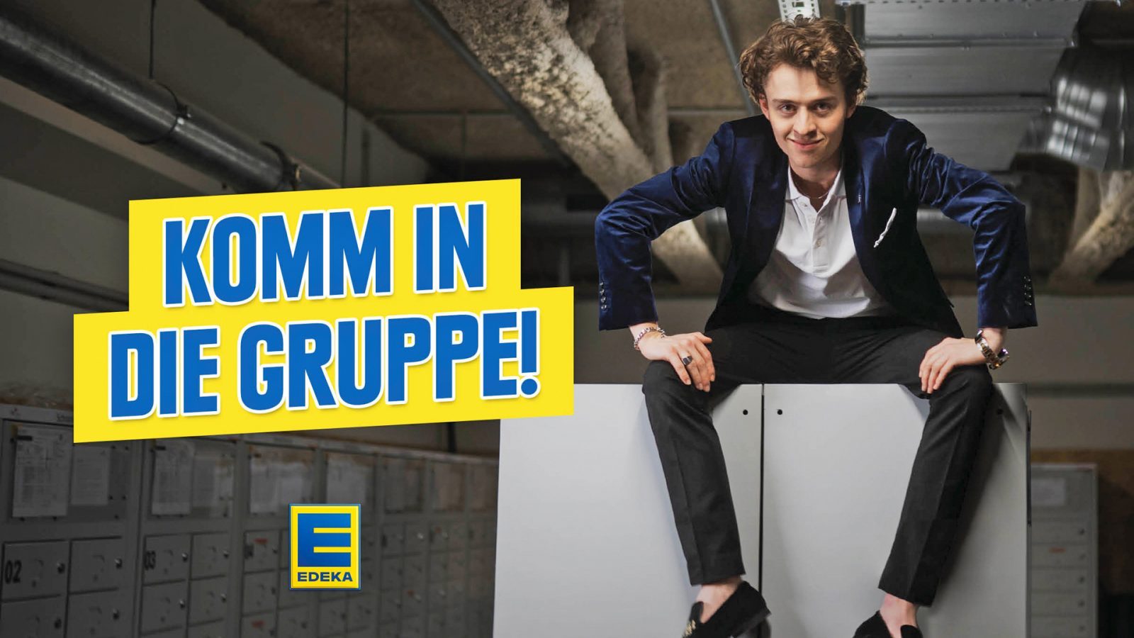 Mann sitzt lässig auf einem weißen Schrank, umgeben von weiteren Aktenschränken, mit dem Slogan 